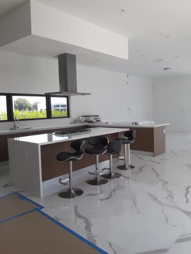 Modern kitchen island with white counter and wood base