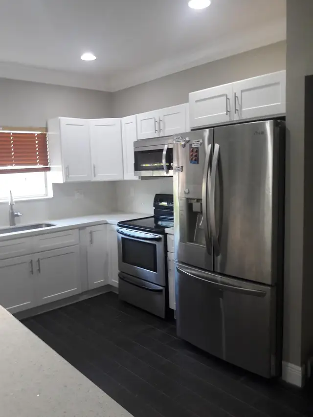 White kitchen remodel with black tile flooring